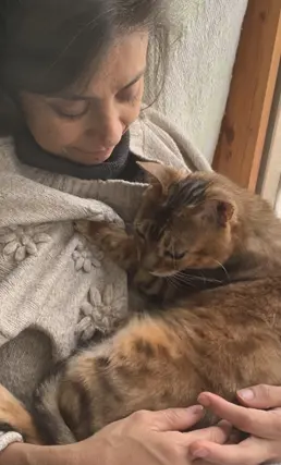 Luisa gently holding her cat — warmth and care in her approach